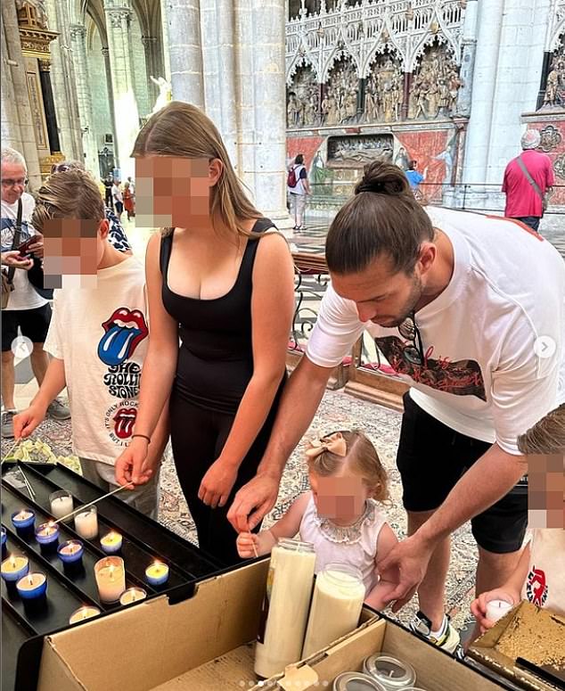 Andy with his children lighting candles at the Cathédrale Notre-Dame in Amiens during a family weekend