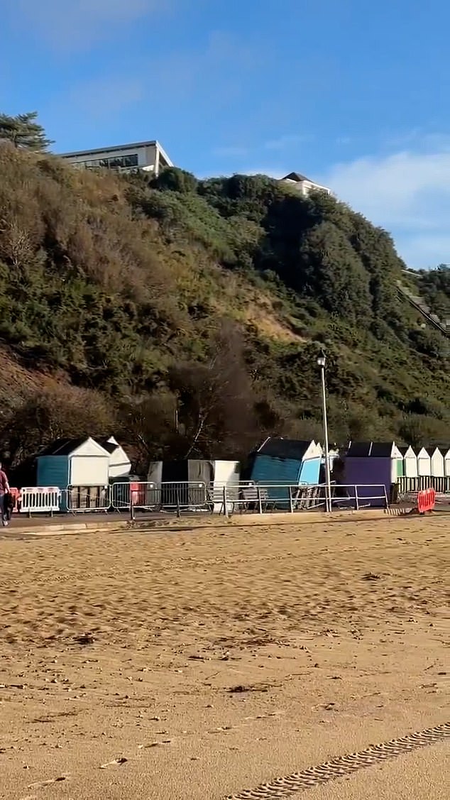 The man narrowly misses the huge landslip from a cliff in Bournemouth