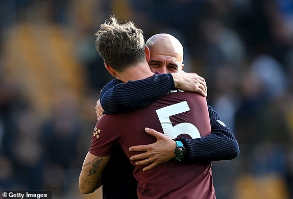 WOLVERHAMPTON, ENGLAND - OCTOBER 20: Pep Guardiola, Manager of Manchester City, embraces John Stones of Manchester City after the team's victory  during the Premier League match between Wolverhampton Wanderers FC and Manchester City FC at Molineux on October 20, 2024 in Wolverhampton, England. (Photo by Shaun Botterill/Getty Images)