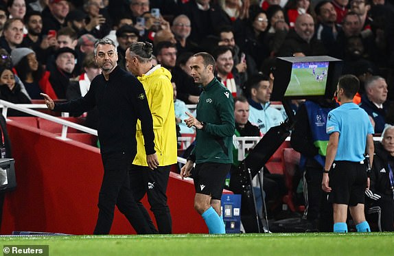 Soccer Football - Champions League - Arsenal v Shakhtar Donetsk - Emirates Stadium, London, Britain - October 22, 2024 Referee Benoit Bastien looks at a VAR screen before awarding Arsenal a penalty kick REUTERS/Dylan Martinez