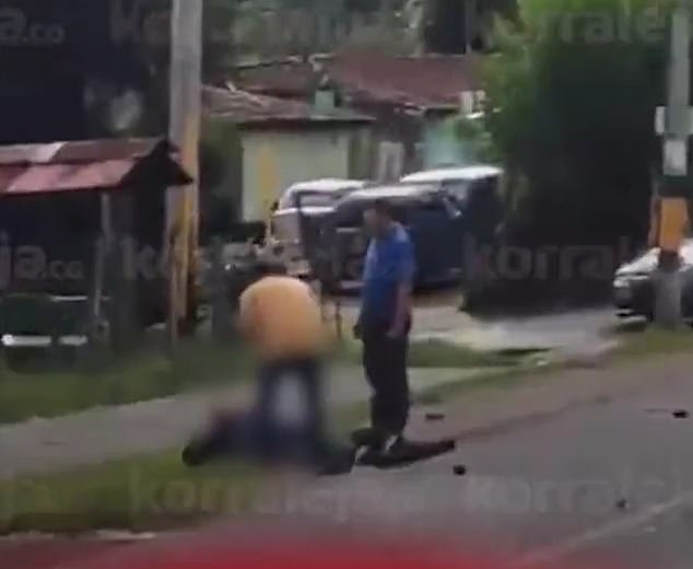 The two onlookers were seen by the side of the road as the motorcyclist attempted to get back to their feet