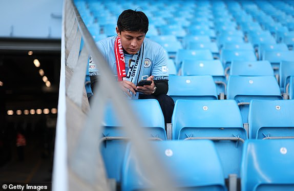 MANCHESTER, ENGLAND - OCTOBER 26: A Manchester City fan looks at their phone inside the stadium prior to the Premier League match between Manchester City FC and Southampton FC at Etihad Stadium on October 26, 2024 in Manchester, England. (Photo by Carl Recine/Getty Images)