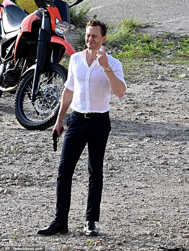 Tom Hiddleston appears to spray something on his face on set of The Night Manager