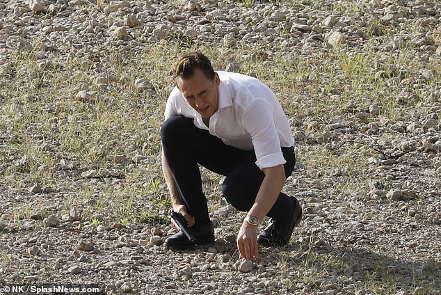 Tom Hiddleston takes a knee as he appears on set of The Night Manager