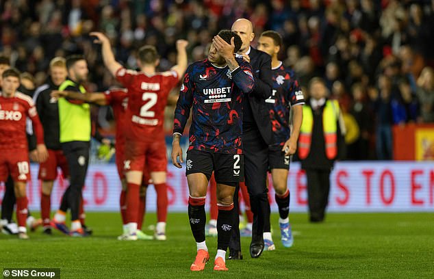 Rangers skipper James Tavernier troops off the pitch as victorious Dons stars celebrate