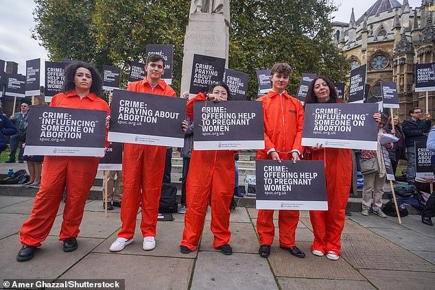 Members of the Society for the Protection of Unborn Children demonstrate outside parliament today