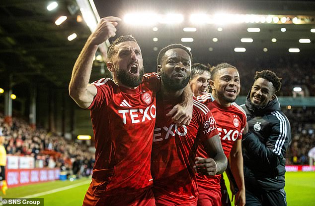 Morris celebrates his famous winner with Graeme Shinnie and team-mates