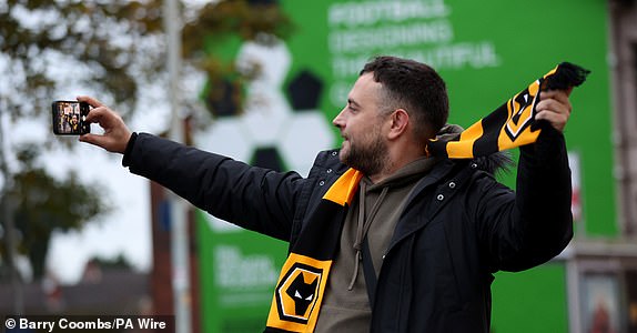 A Wolverhampton Wanderers fan takes a selfie outside the ground before the Premier League match at Molineux, Wolverhampton. Picture date: Saturday November 2, 2024. PA Photo. See PA story SOCCER Wolves. Photo credit should read: Barry Coombs/PA Wire.RESTRICTIONS: EDITORIAL USE ONLY No use with unauthorised audio, video, data, fixture lists, club/league logos or "live" services. Online in-match use limited to 120 images, no video emulation. No use in betting, games or single club/league/player publications.