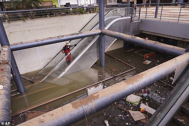 A firefighter looks at the flooded damage in a shopping centre after floods on the outskirts of Valencia, Spain, November 4