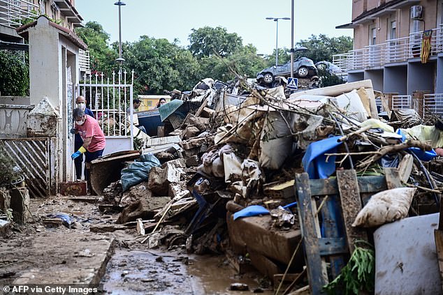 People continue clean up work following devastating floods in Alfafar, in the region of Valencia, eastern Spain, on November 4