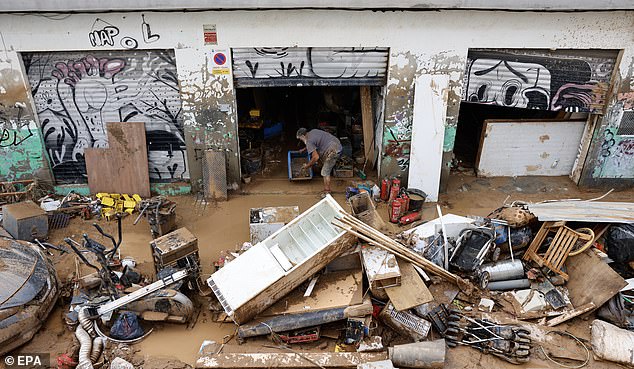 A man clears the debris and mud on his property following last week's floods in the municipality of Sedavi