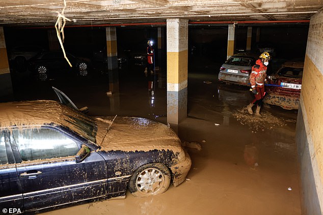 Firefighters search for victims at an underground parking lot following last week's floods in the municipality of Sedavi, province of Valencia, on November 4