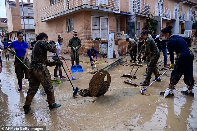 Members of the military and volunteers work in clean up efforts in Alfafar, in the region of Valencia, eastern Spain, on November 4