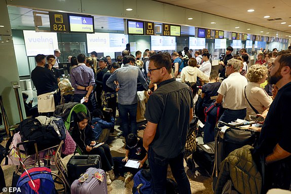 epa11700904 Passengers wait at El Prat Airport after several flights were canceled due to heavy rains, in Barcelona, Catalonia, Spain, 04 November 2024. Spain's airport operator AENA on 04 November said at least 70 flights scheduled to take off from Josep Tarradellas Barcelona-El Prat Airport were cancelled, while 18 others were rerouted, after a heavy rainstorm hit the Barcelona area in the morning. According to Rodalies Catalunya, all local train lines are suspended until the end of civil protection alerts due to the adverse weather conditions.  EPA/TONI ALBIR