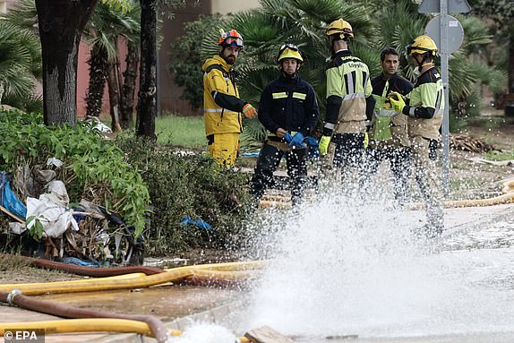 epa11700390 Spanish national police and firefighters stand in a parking area in the municipality of Aldaia, province of Valencia, Spain, 04 November 2024. The devastating floods in Valencia and neighboring provinces have caused at least 213 fatalities as efforts to search for missing people, provide supplies and care for the victims continue almost one week since the DANA (high-altitude isolated depression) weather phenomenon hit the east of the country.  EPA/KAI FORSTERLING