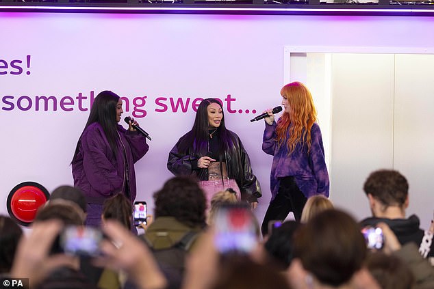 The girl group shocked passers by as they appeared out of a large Sky Broadband platform set up in the train station