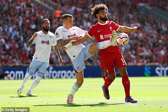 LIVERPOOL, ENGLAND - SEPTEMBER 03: Lucas Digne of Aston Villa battles for possession with Mohamed Salah of Liverpool during the Premier League match between Liverpool FC and Aston Villa at Anfield on September 03, 2023 in Liverpool, England. (Photo by Matt McNulty/Getty Images)