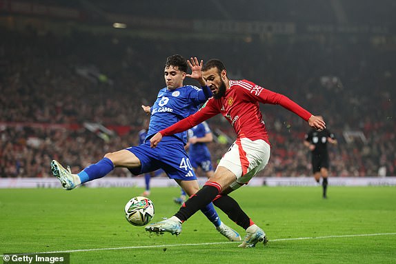 MANCHESTER, ENGLAND - OCTOBER 30: Noussair Mazraoui of Manchester United takes a shot under pressure from Facundo Buonanotte of Leicester City during the Carabao Cup Fourth Round match between Manchester United and Leicester City at Old Trafford on October 30, 2024 in Manchester, England. (Photo by Nathan Stirk/Getty Images)