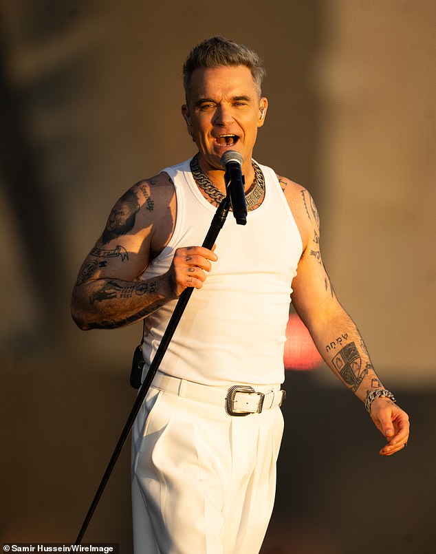 Robbie Williams has admitted he never felt his 'place within Take That was safe' after he was almost kicked out of the band when he was just 16-years-old (pictured in July)