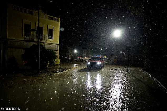 A police vehicle crosses a bridge in the rain following catastrophic flooding, as Spain braces for more torrential rain, in Paiporta, Valencia, Spain November 13, 2024