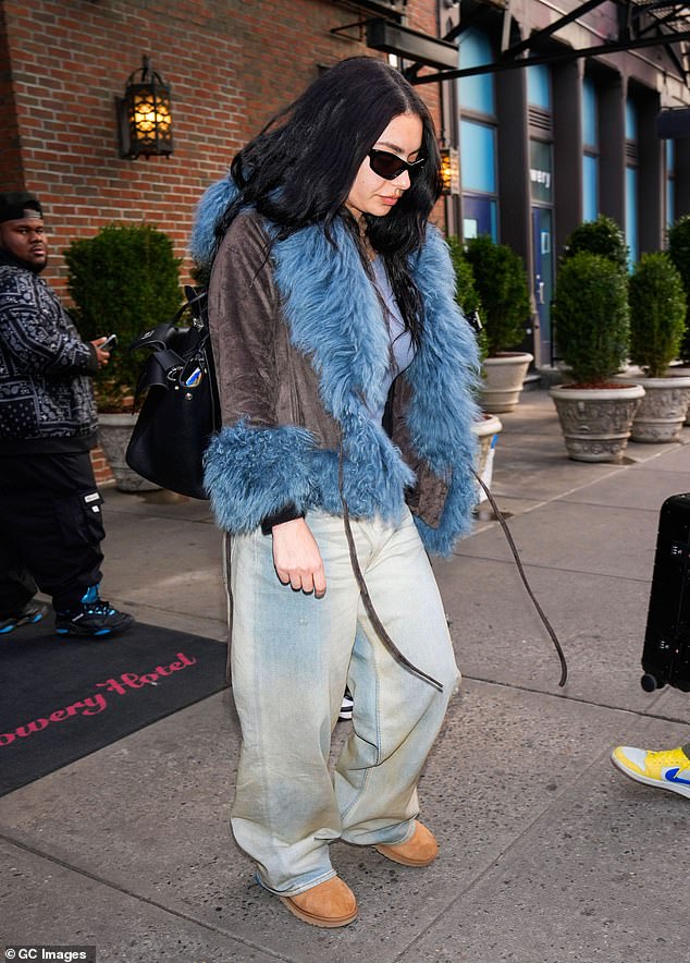 The singer, 32, wrapped up in a brown jacket with a blue faux fur lining which she wore with a pair of baggy light wash jeans