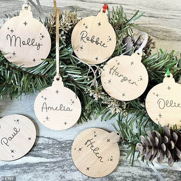 Pictured: the £1.50 personalised wooden Christmas tree decorations that are best-sellers on Etsy