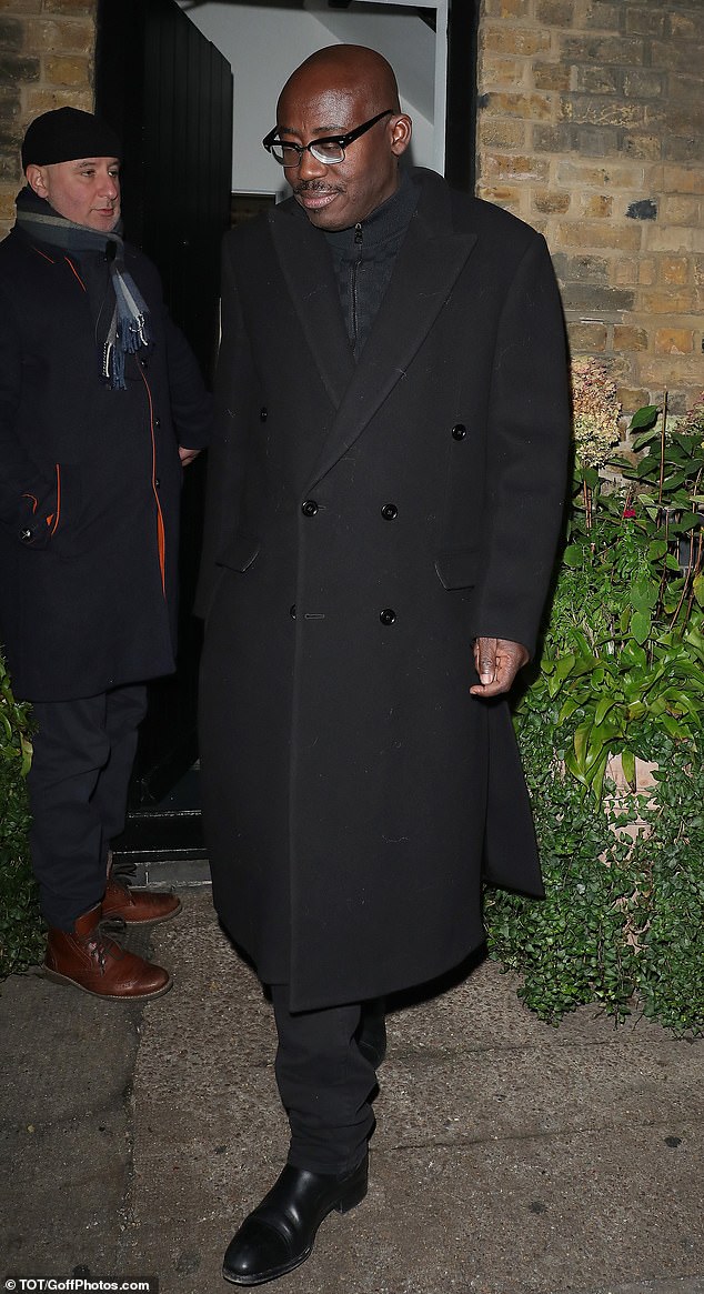 Former British Vogue editor Edward Enninful wrapped up in a black knee-length coat along with a pair of matcing trousers and boots