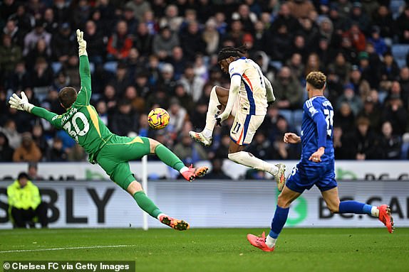 LEICESTER, ENGLAND - NOVEMBER 23: Noni Madueke of Chelsea takes a shot under pressure from Mads Hermansen of Leicester City during the Premier League match between Leicester City FC and Chelsea FC at The King Power Stadium on November 23, 2024 in Leicester, England. (Photo by Darren Walsh/Chelsea FC via Getty Images)