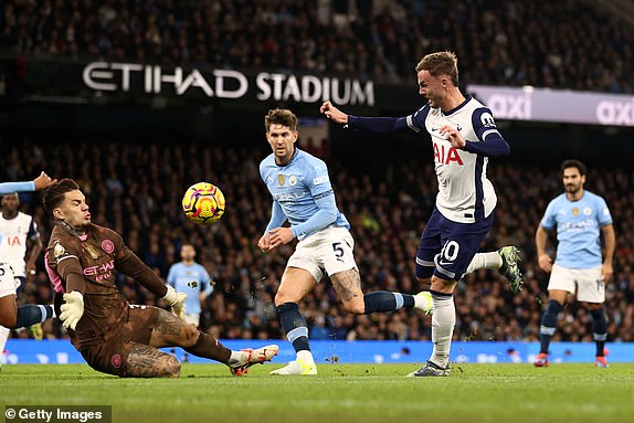 MANCHESTER, ENGLAND - NOVEMBER 23: James Maddison of Tottenham Hotspur scores his team's second goal past Ederson of Manchester City during the Premier League match between Manchester City FC and Tottenham Hotspur FC at Etihad Stadium on November 23, 2024 in Manchester, England. (Photo by Naomi Baker/Getty Images)