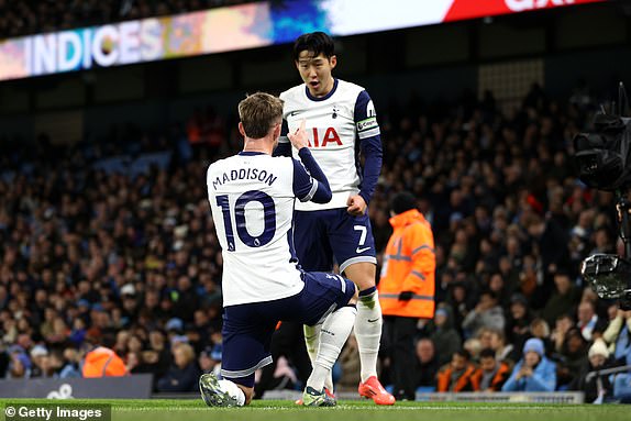 MANCHESTER, ENGLAND - NOVEMBER 23: James Maddison of Tottenham Hotspur celebrates scoring his team's second goal with team mate Son Heung-Min during the Premier League match between Manchester City FC and Tottenham Hotspur FC at Etihad Stadium on November 23, 2024 in Manchester, England. (Photo by Naomi Baker/Getty Images)