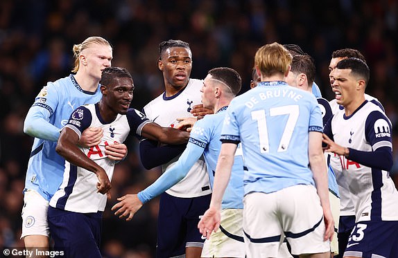 MANCHESTER, ENGLAND - NOVEMBER 23: Yves Bissouma of Tottenham Hotspur is held back by Erling Haaland of Manchester City whilst clashing with Phil Foden of Manchester City during the Premier League match between Manchester City FC and Tottenham Hotspur FC at Etihad Stadium on November 23, 2024 in Manchester, England. (Photo by Naomi Baker/Getty Images)