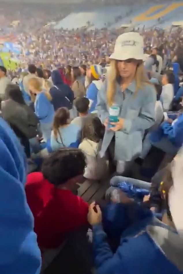 This woman in a hat slapped the man wearing a red sweatshirt at a college football game