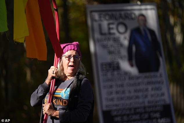 Sheila Eddison protests in front of the home of Leonard Leo