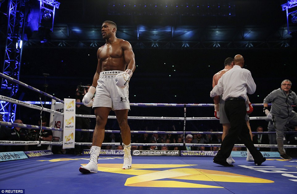 The Olympic champions walks back to his corner while Klitschko is escorted back to his own by the referee