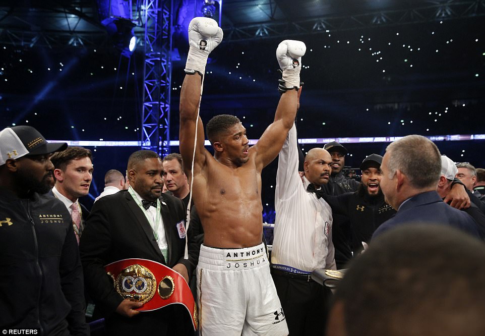 Field holds Joshua's hand up to signify the Brit's victory in front of 90,000 supporters at the home of English football