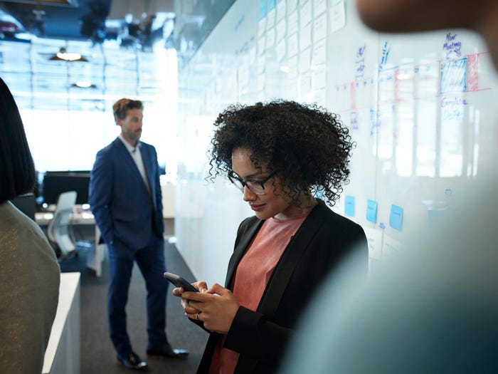 woman in office using smartphone