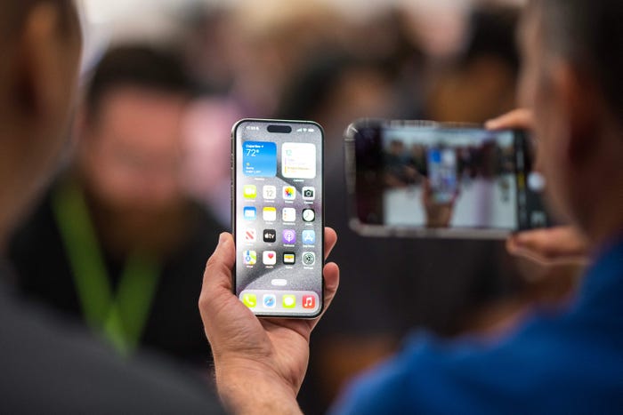 A person photographs an Apple iPhone 15 Pro using another iPhone