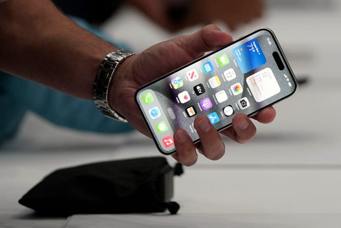 A close-up of a person's hand holding an iPhone.