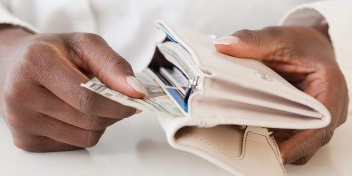 A woman pulls money out of wallet