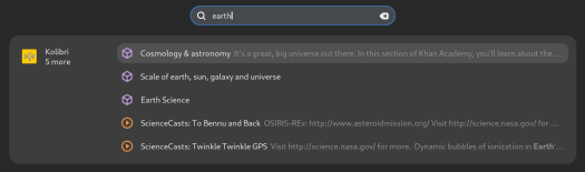 A screenshot of GNOME Shell, showing search results after entering "earth" in the search bar. Several results from Kolibri are displayed, such as "Cosmology & astronomy". The results include titles and descriptions. The first three results have purple box icons, indicating that they are interactive. The other two results have orange Play button icons, indicating that they are videos.