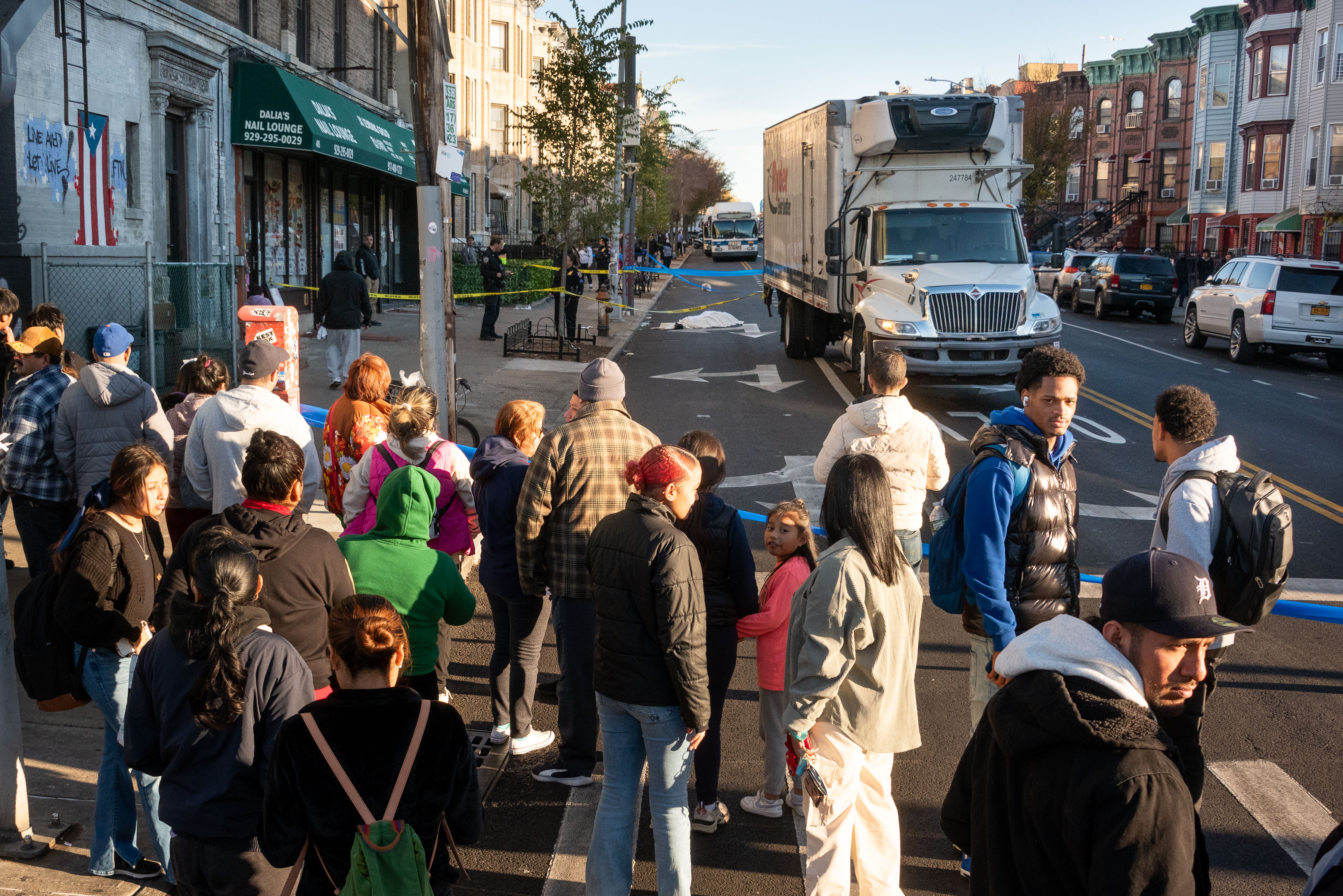 A crowd looks on after a man was fatally struck by a truck on 60th St. near 4th Ave. in Sunset Park, Brooklyn, on Friday, Nov. 15, 2024. (Gardiner Anderson / New York Daily News)