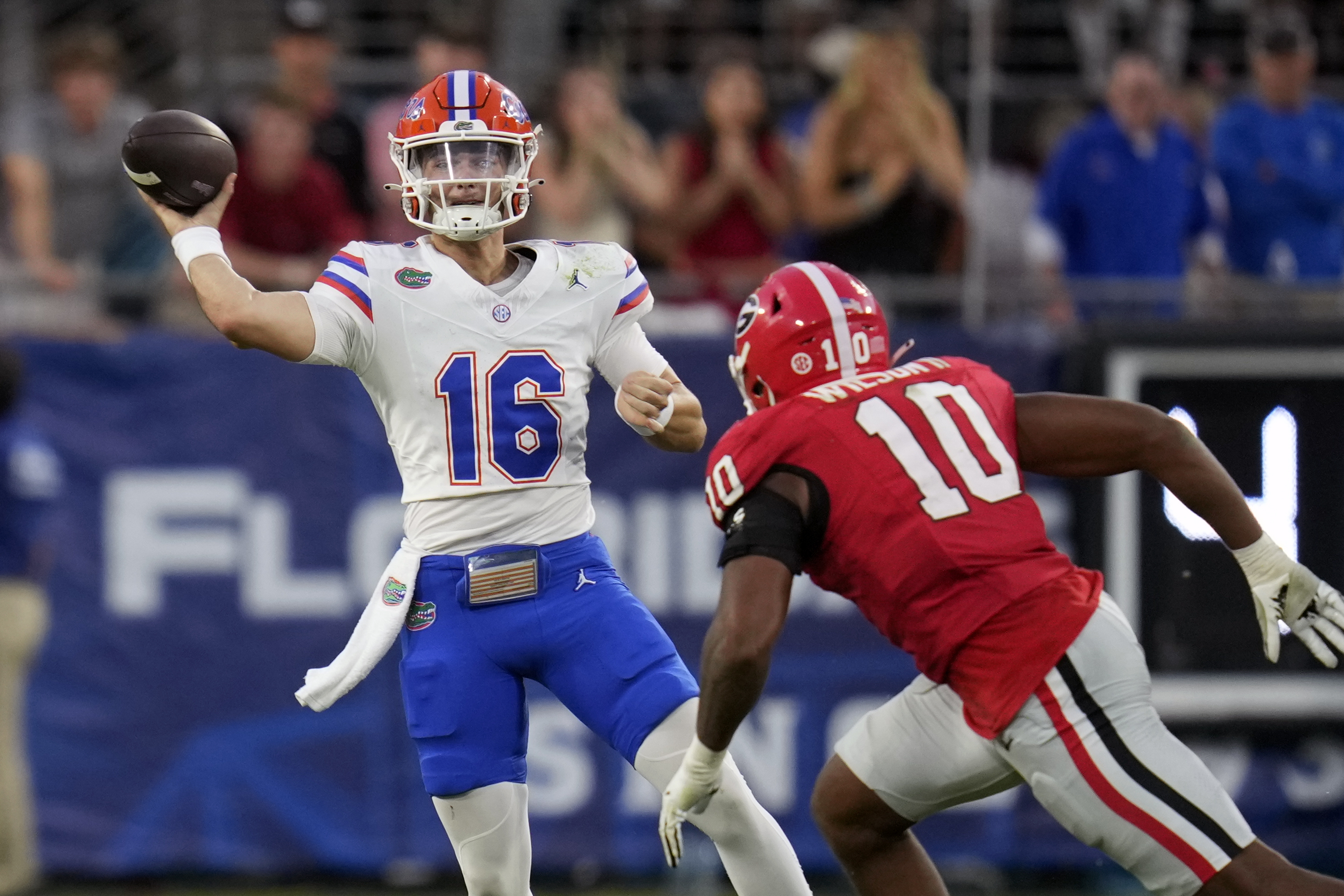 Florida quarterback Aidan Warner (16) throws a pass as he is pressured by Georgia linebacker Damon Wilson II (10) during the second half of an NCAA college football game, Saturday, Nov. 2, 2024, in Jacksonville, Fla. (AP Photo/John Raoux)