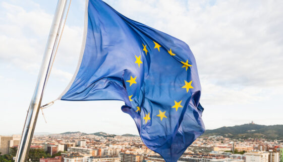 EU flag fluttering by wind above Barcelona