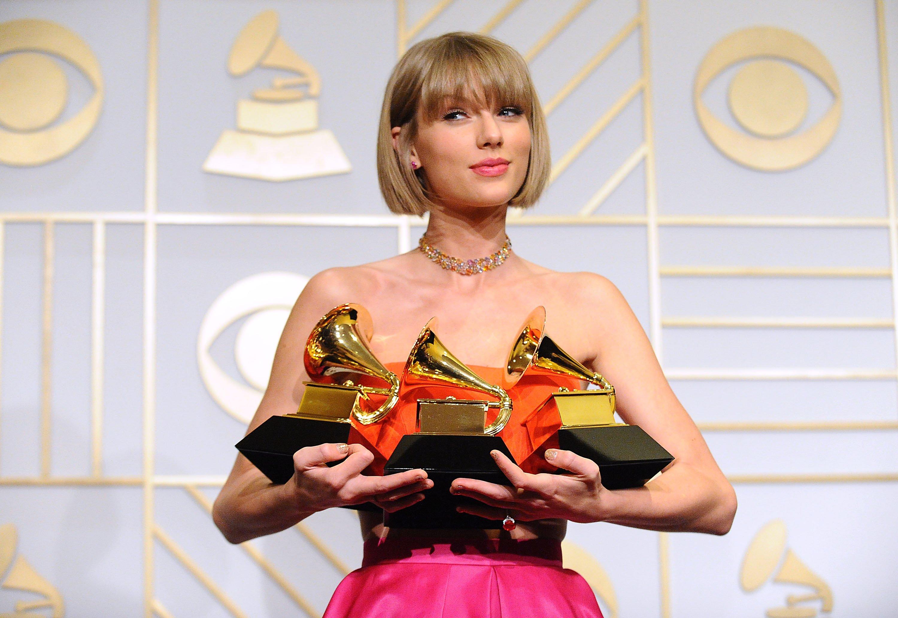 Taylor Swift holding GRAMMYs