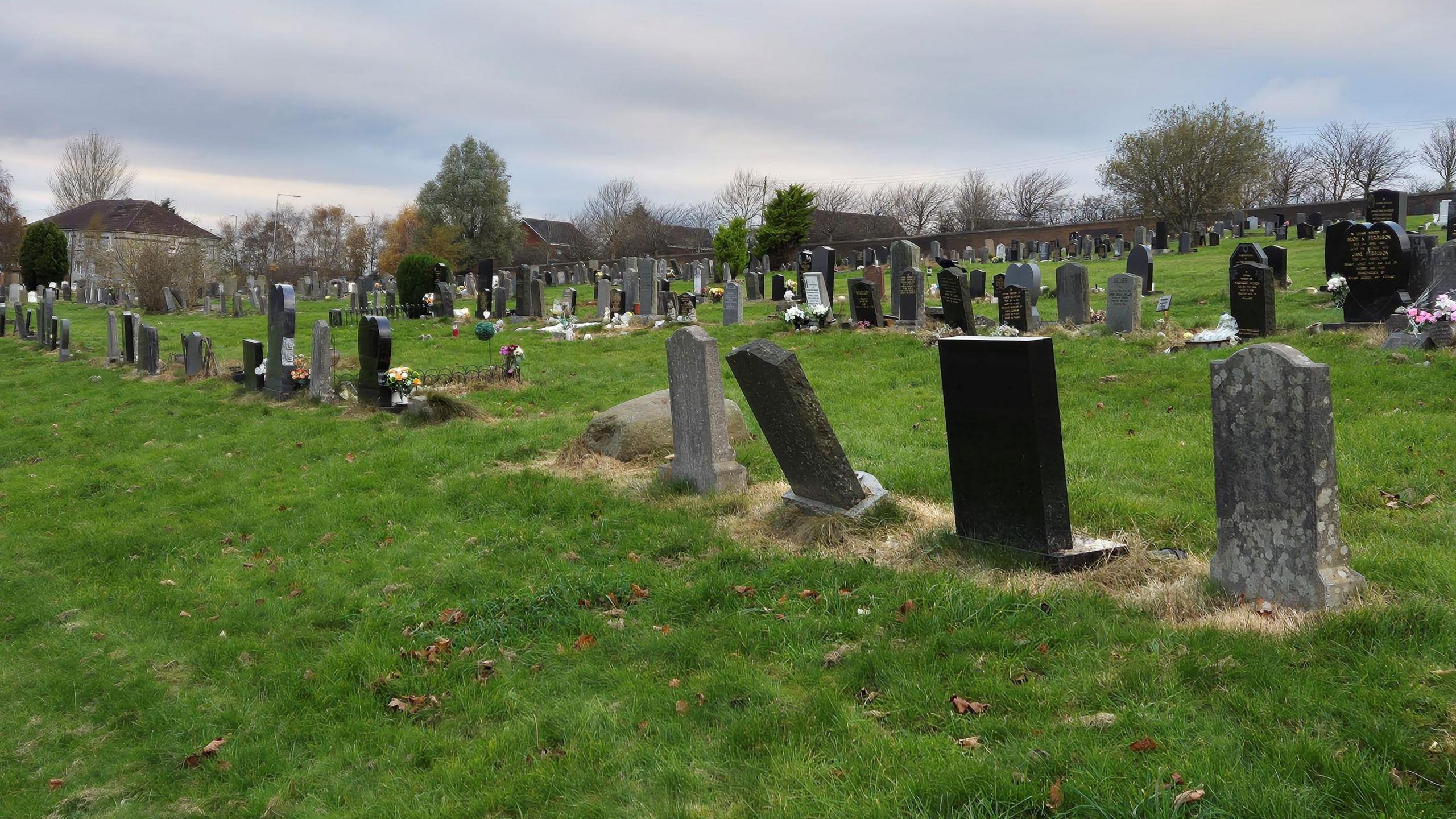 A GV of rows of graves at Riddrie Park Cemetery, on a cloudy, autumn day