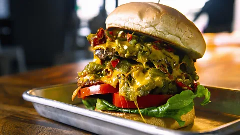 Green chile cheeseburger on metal tray (Credit: Getty Images)