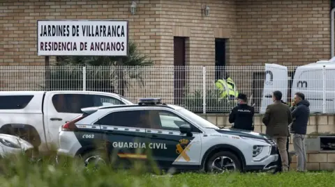 JAVIER CEBOLLADA/EPA-EFE Police stand outside the Jardines De Villafranca retirement home near Zaragoza after a fire leaves 10 people dead