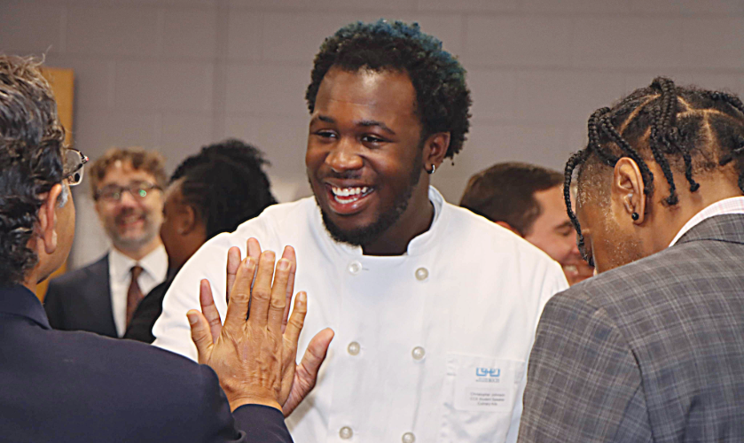 smiling student high-fives board of education member