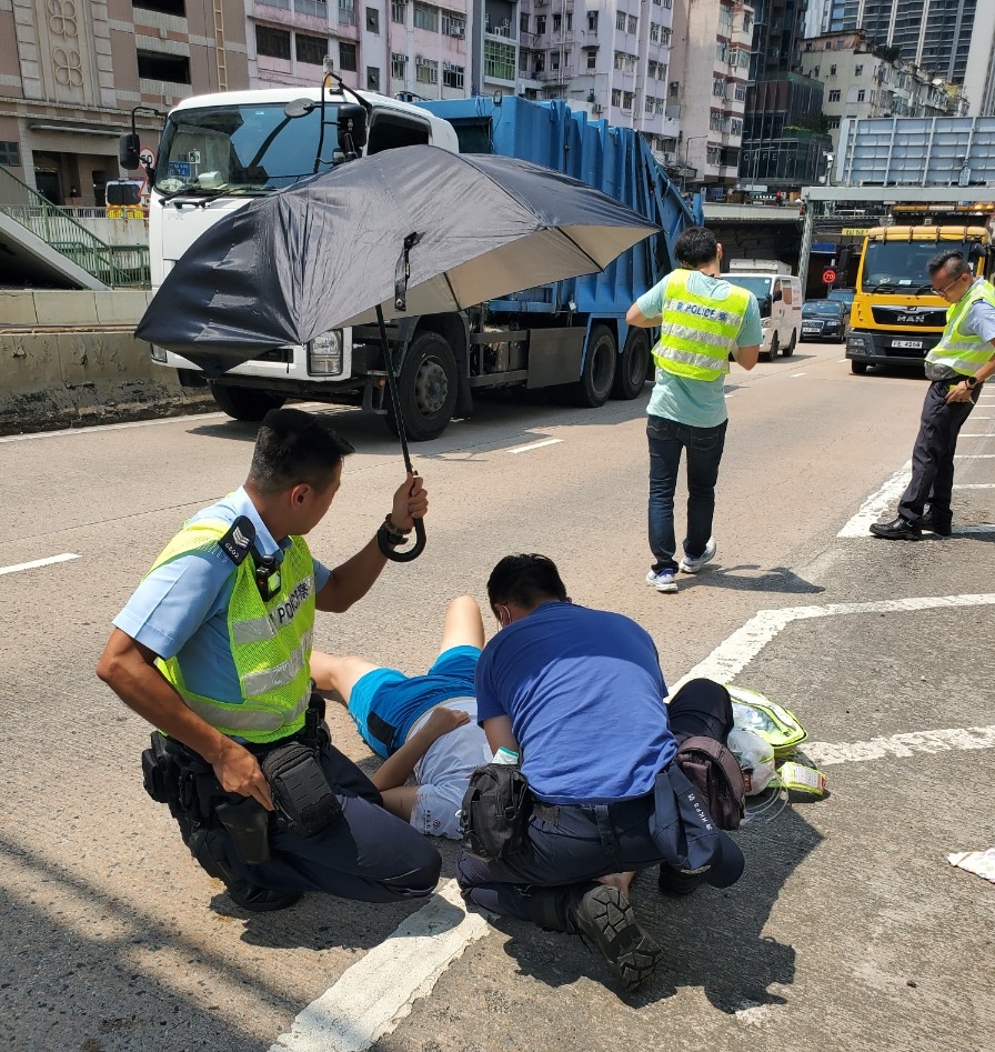 警員為女傷者打傘遮擋陽光。