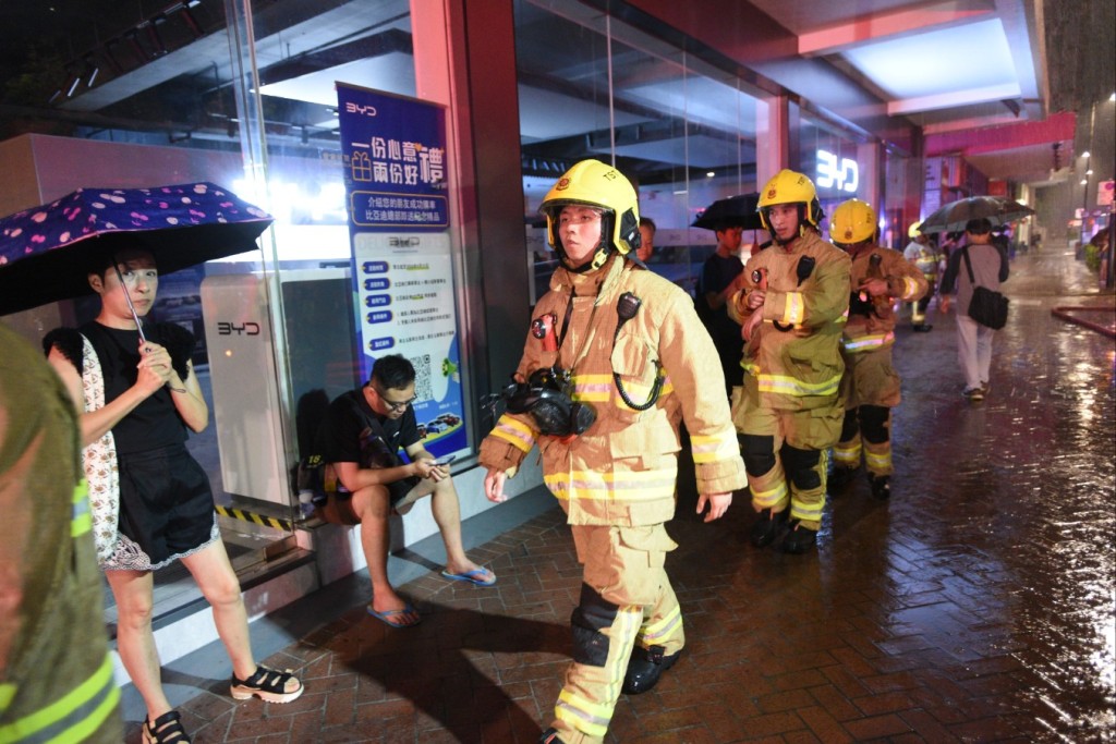 有商戶需要冒雨疏散逃生。尹敬堂攝